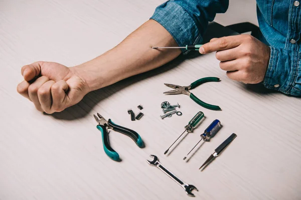 Vista recortada del hombre reparando la mano con destornillador - foto de stock