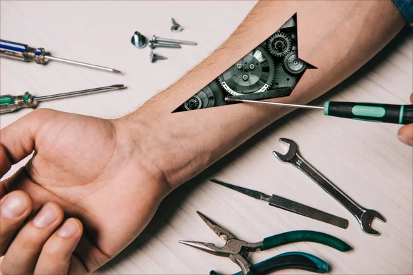 Cropped view of man fixing hand with metallic tools — Stock Photo