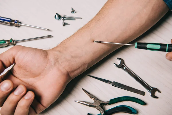 Ausgeschnittene Ansicht eines Mannes, der Hand mit Werkzeug fixiert — Stockfoto