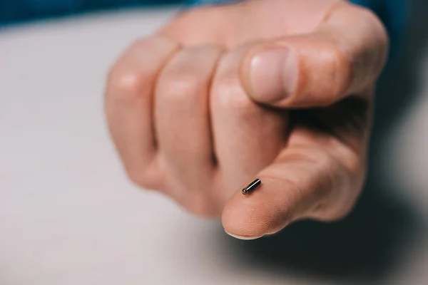 Vista recortada del hombre sosteniendo el microchip en el dedo - foto de stock