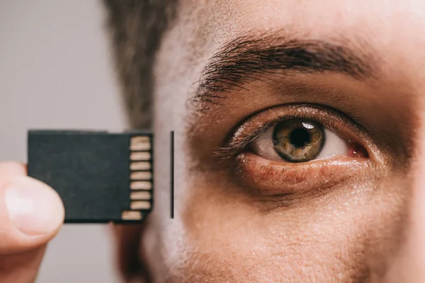 Vista recortada del hombre insertando chip en la cabeza aislada en gris - foto de stock