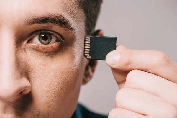 Selective focus of man implanting microchip in head isolated on grey — Stock Photo