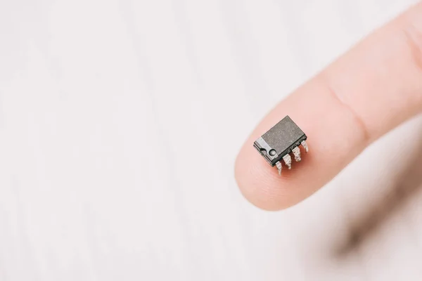 Selective focus of man holding black, metallic microchip — Stock Photo