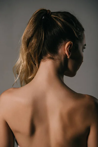 Вид ззаду дівчини з хвостом на сірому фоні — стокове фото