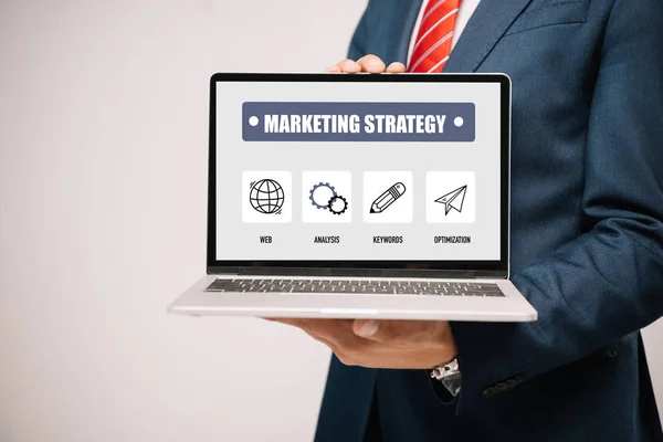 Abgeschnittene Ansicht von Geschäftsmann im Anzug präsentiert Laptop mit Marketing-Strategie isoliert auf grau — Stockfoto