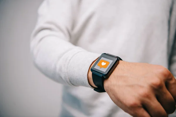 Cropped view of man with smartwatch with multimedia like icon — Stock Photo