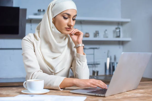Bella giovane donna musulmana utilizzando il computer portatile a casa — Foto stock