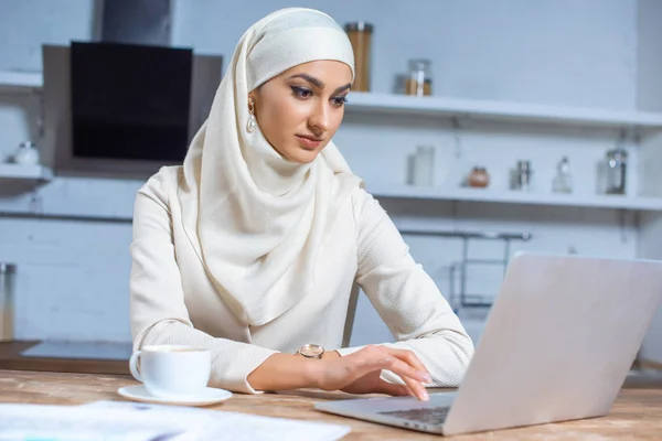 Jovem mulher muçulmana atraente usando laptop em casa — Fotografia de Stock