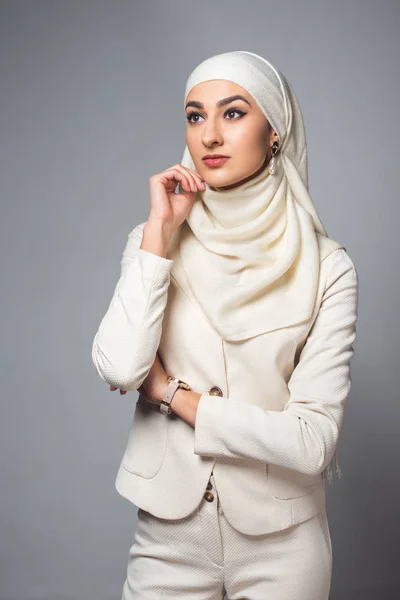 Schöne nachdenkliche junge muslimische Frau, die isoliert auf grau schaut — Stockfoto