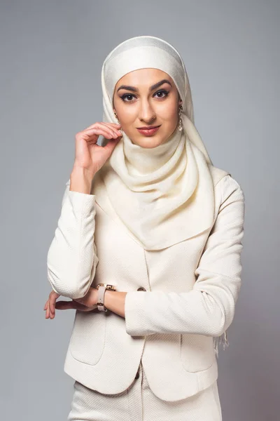 Retrato de hermosa joven musulmana sonriendo a la cámara aislada en gris - foto de stock