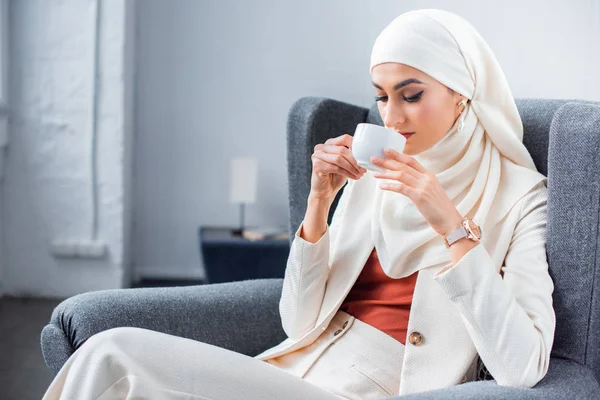 Joven musulmana bebiendo café en casa - foto de stock