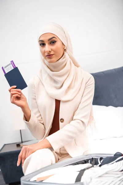 Giovane donna musulmana in possesso di passaporto con carta d'imbarco e guardando la fotocamera — Foto stock