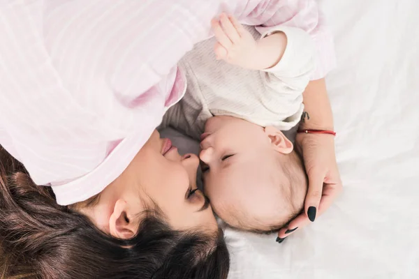 Vista aérea de la madre y el pequeño hijo durmiendo en la cama juntos - foto de stock