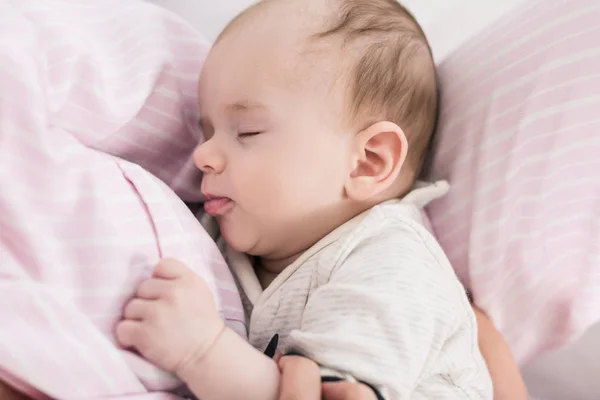 Vista parcial de lindo bebé durmiendo en las manos de las madres — Stock Photo
