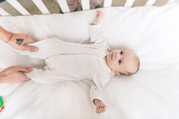 Partial view of father and little baby lying in crib — Stock Photo