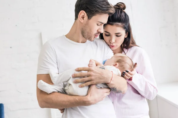 Retrato de padres jóvenes y lindo bebé pequeño con chupete en casa - foto de stock