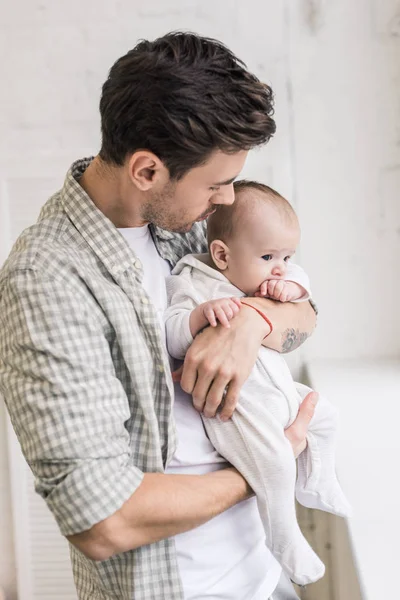 Vista lateral do jovem pai e bebê em casa — Fotografia de Stock