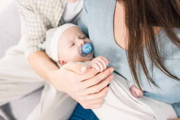 Vista parcial de los padres y el pequeño bebé con chupete - foto de stock