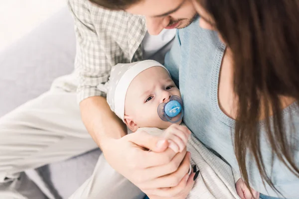 Partial view of parents and little baby with pacifier — Stock Photo