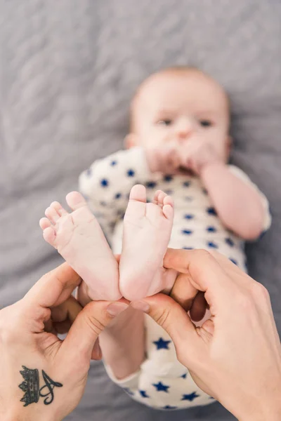 Colpo ritagliato di padre che tiene piccoli piedi di figli in mani — Foto stock
