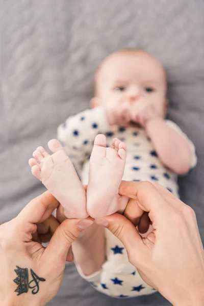 Plan recadré du père tenant les petits fils pieds dans les mains — Photo de stock