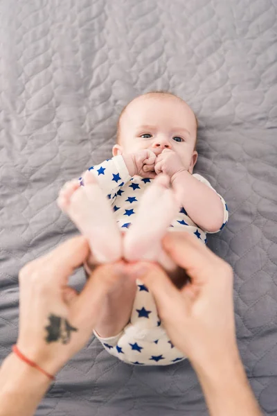 Cropped shot of father holding little sons feet in hands — Stock Photo