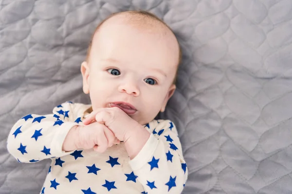 Overhead view of adorable little baby lying on grey blanket — Stock Photo