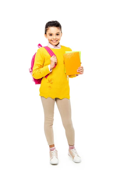 Adorable kid holding books and smiling at camera isolated on white — Stock Photo