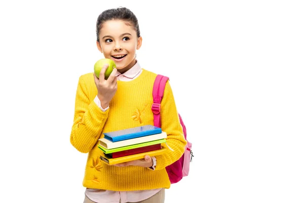 Adorable child eating apple and holding books isolated on white — Stock Photo