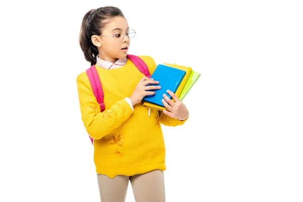 Surprised schoolchild in glasses holding books isolated on white — Stock Photo