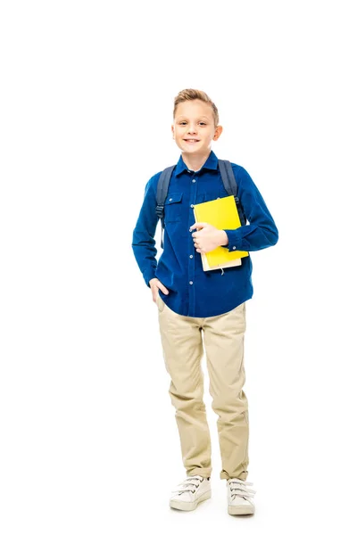 Netter Schuljunge in blauem Hemd mit Rucksack, der Bücher isoliert auf weißem Papier hält — Stockfoto