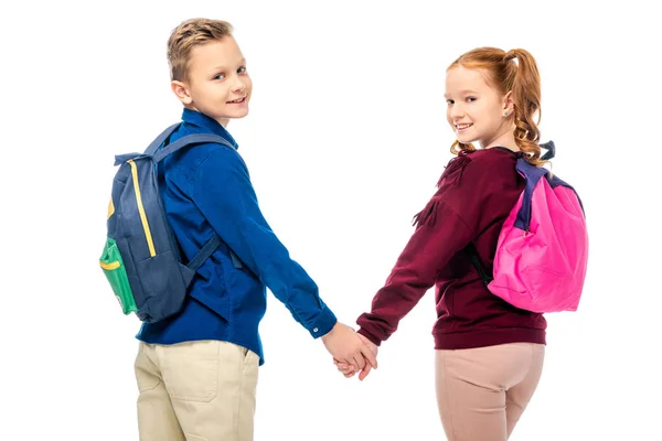 Schoolkids holding hands and smiling at camera isolated on white — Stock Photo