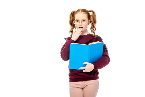 Sorprendido adorable escolar en gafas celebración libro aislado en blanco - foto de stock