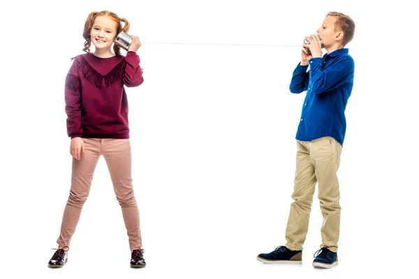 Lächelnde Kinder spielen mit Dosen, die durch ein Seil verbunden sind, isoliert auf weiß — Stockfoto