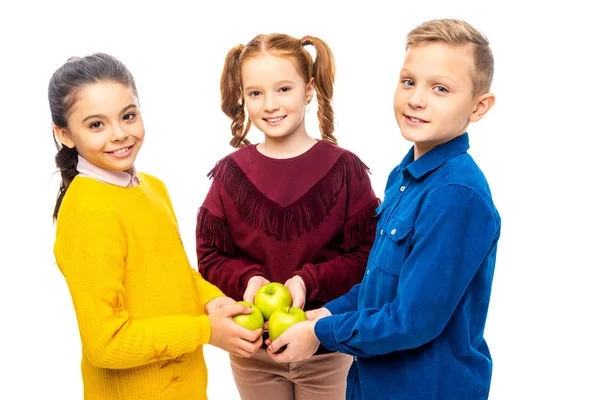 Niños sonrientes sosteniendo manzanas y mirando a la cámara aislada en blanco - foto de stock