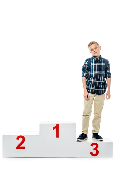 Disappointed boy standing on winner podium and looking at camera isolated on white — Stock Photo