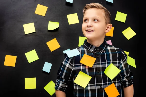 Cute boy with multicolored stickers on black background — Stock Photo