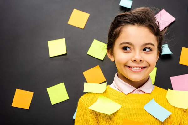 Scolaretta sorridente con adesivi multicolore su sfondo nero — Foto stock