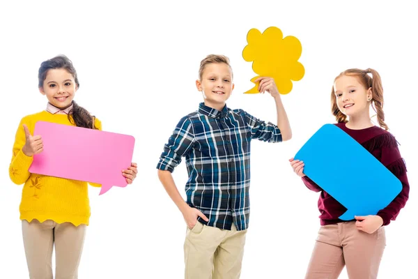 Cheerful preteen kids holding multicolored speech bubbles, showing thumb up and looking at camera isolated on white — Stock Photo
