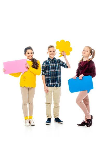 Niños felices sonriendo, sosteniendo burbujas de habla multicolores y mirando a la cámara aislada en blanco - foto de stock