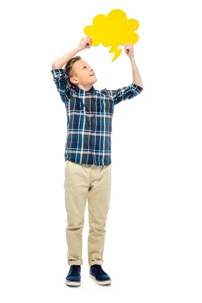 Smiling boy looking at yellow speech bubble over head isolated on white — Stock Photo