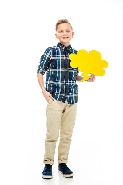 Smiling boy holding yellow speech bubble and looking at camera isolated on white — Stock Photo