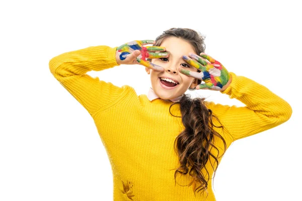 Écolière joyeuse avec bouche ouverte en pull jaune regardant la caméra et montrant les mains peintes dans des peintures colorées isolées sur blanc — Photo de stock