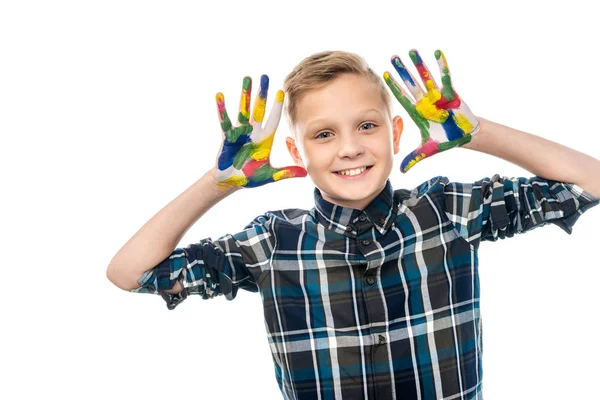 Menino sorrindo mostrando as mãos pintadas em tintas coloridas e olhando para a câmera isolada em branco — Fotografia de Stock
