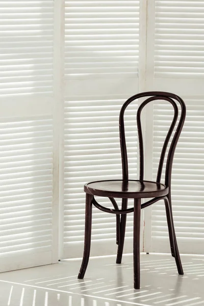 Чорний дерев'яний стілець і білий роздільник кімнати з тінями — стокове фото