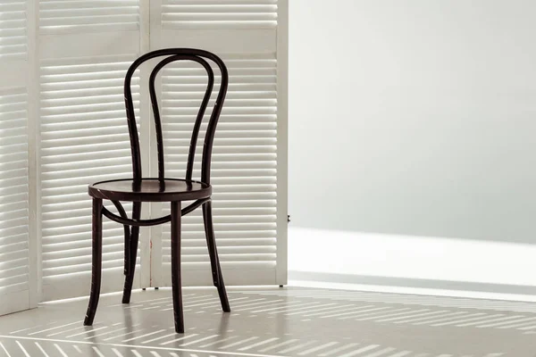 Black wooden chair and white room divider — Stock Photo