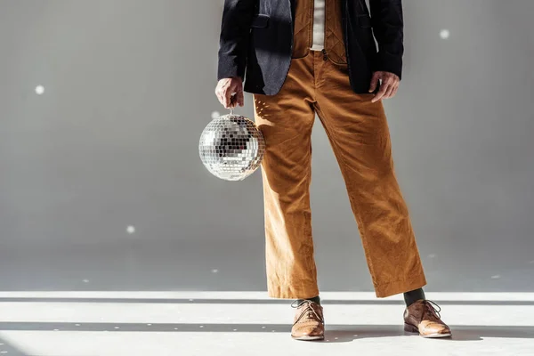 Cropped view of man holding mirror ball on grey background — Stock Photo