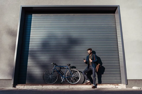 Bel homme barbu dans des lunettes debout près du vélo — Photo de stock