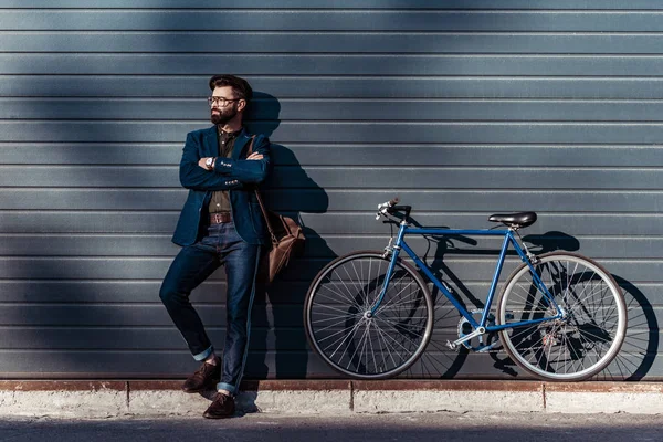 Красивий бородатий чоловік в окулярах і шапка позує біля велосипеда — стокове фото