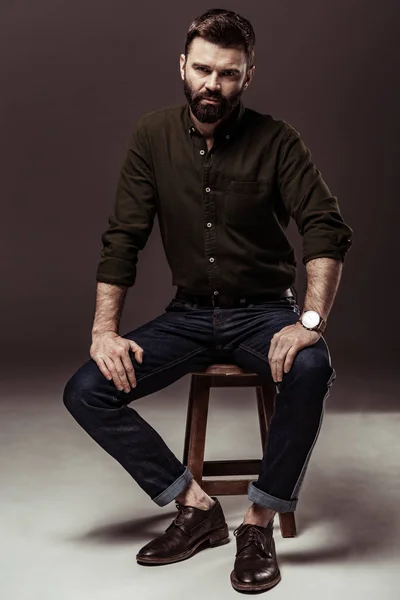 Handsome bearded man in brown shirt looking at camera — Stock Photo